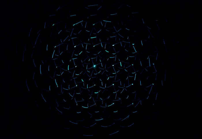 Abstract spiral of blue and green light lines on black background