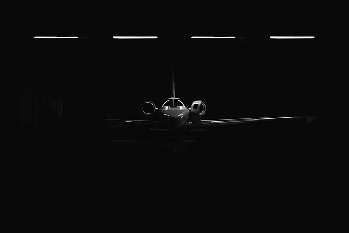 Private jet parked in a dark hangar