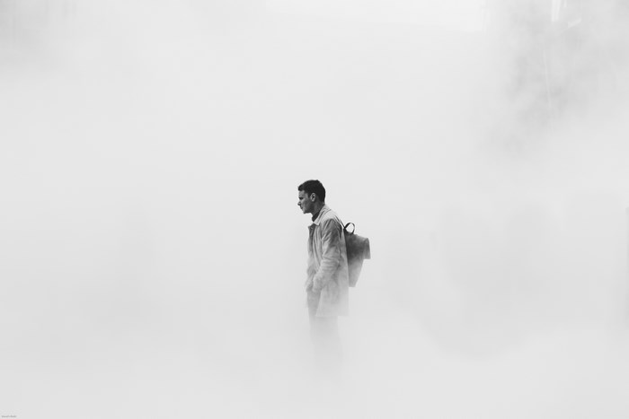 Man with backpack in fog