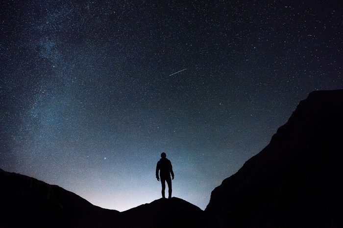 Man silhouetted against a starry night sky