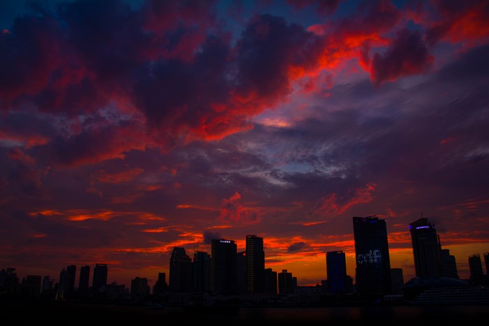 City skyline at sunset with dramatic red and purple clouds