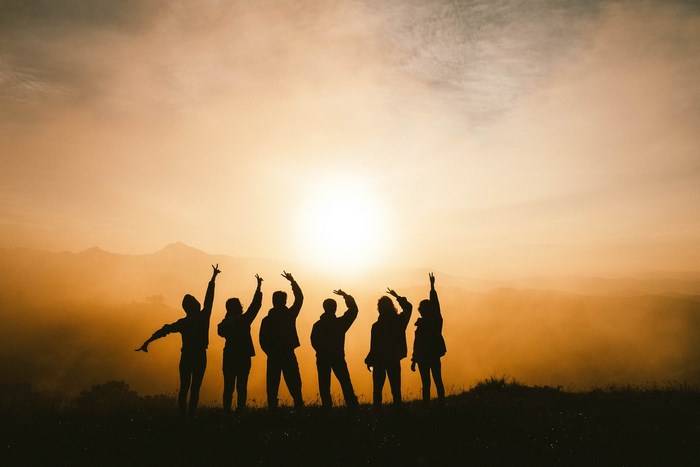 Silhouettes of Friends Celebrating at Sunrise
