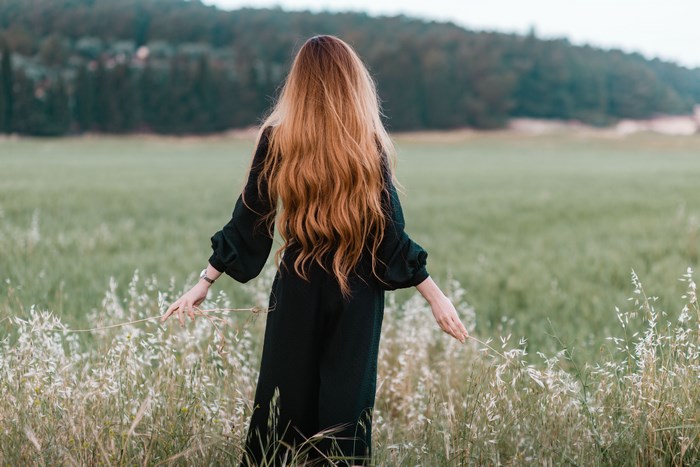 Woman with long red hair in a field