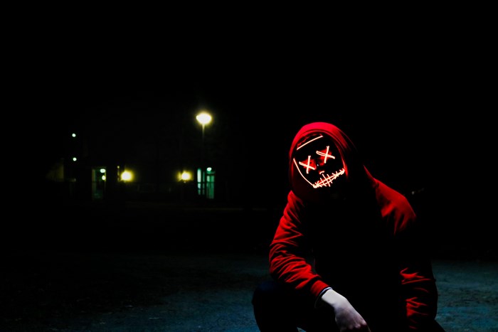 Mysterious Figure in Red Hoodie with Glowing Mask