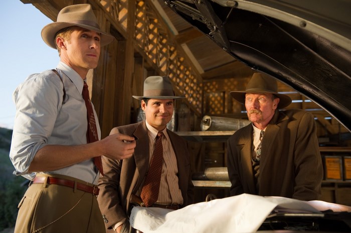 Three men in hats looking at a car engine