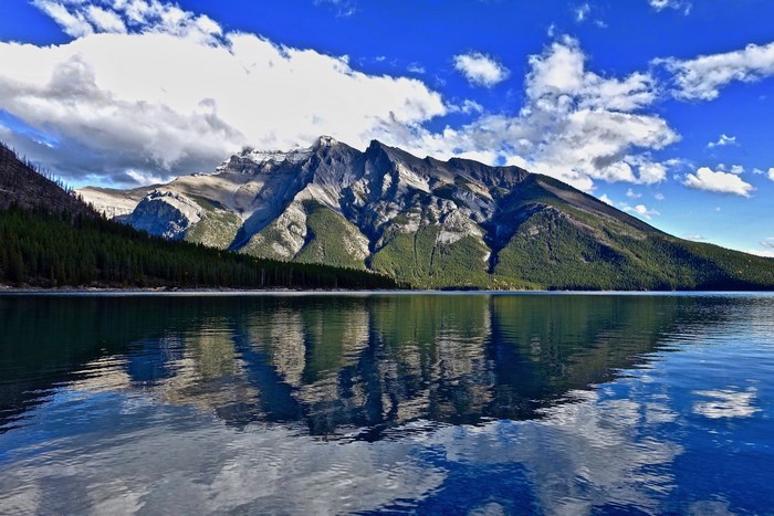Mountain range reflected in a lake under a blue sky
