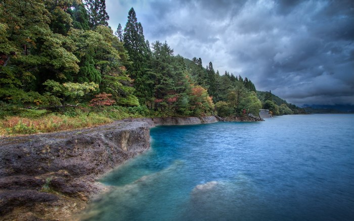 Lake with forest and stormy sky