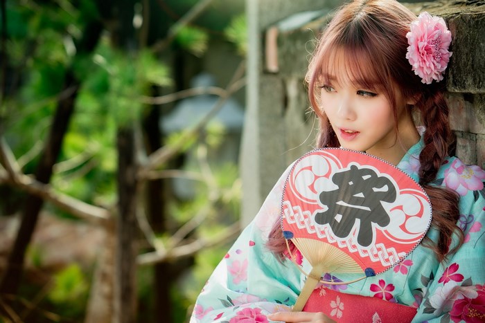 Young Woman in Traditional Japanese Attire Holding Fan
