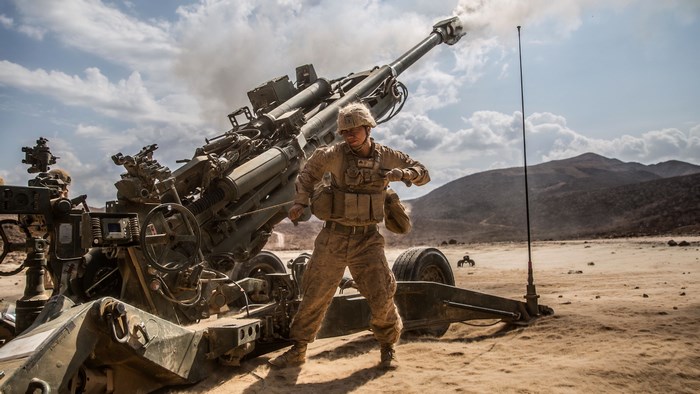Soldier firing M777 Howitzer in desert
