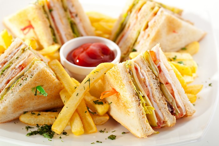 Club sandwiches with french fries and ketchup