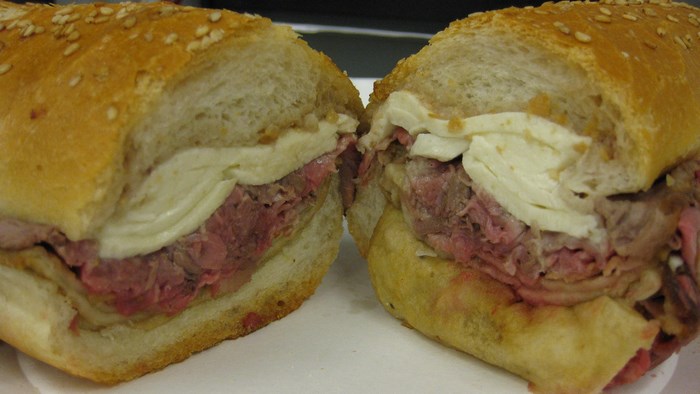 Roast beef and cheese sandwich on a sesame seed bun