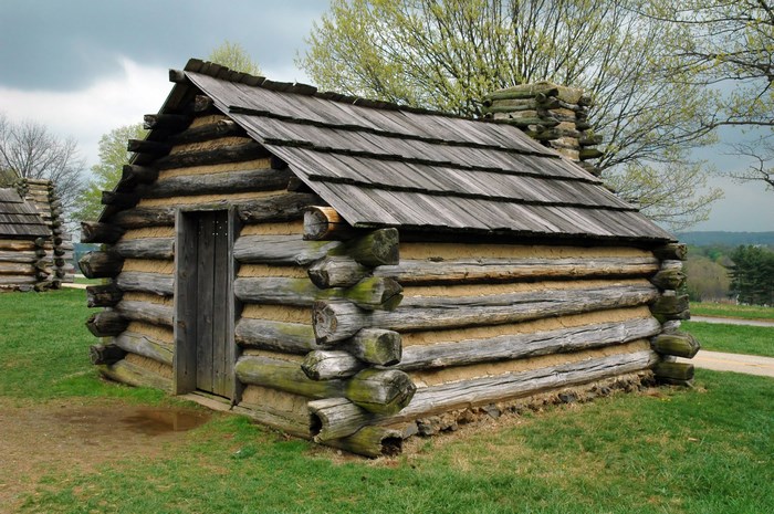 Log cabin with wooden roof and stone chimney