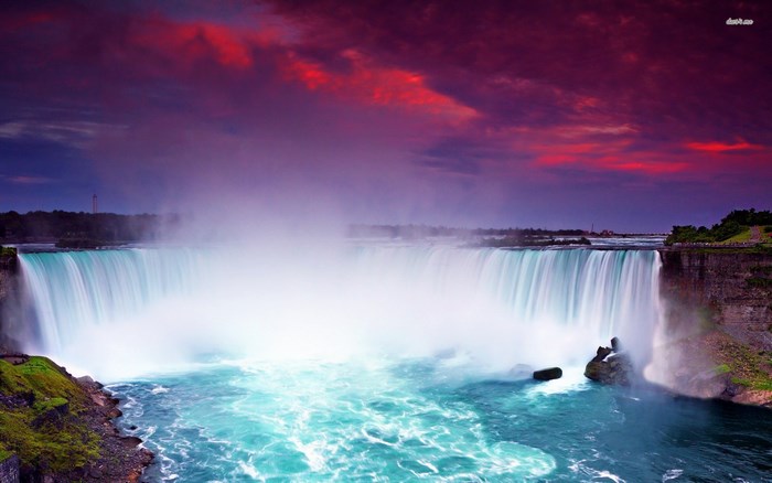 Niagara Falls at sunset with purple and red clouds
