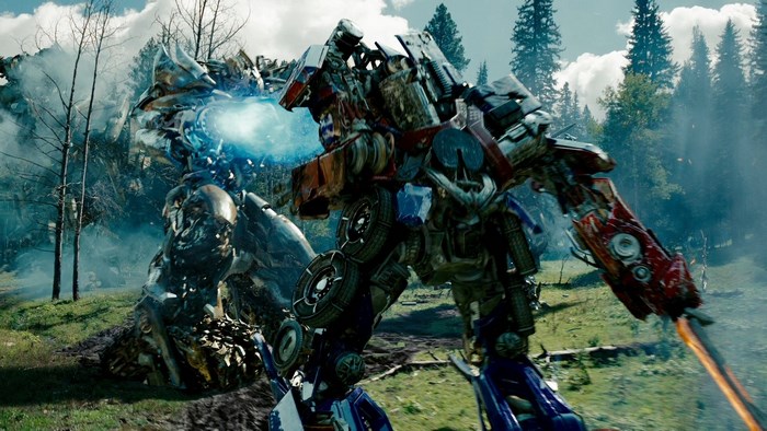 Optimus Prime fighting another Transformer in a forest