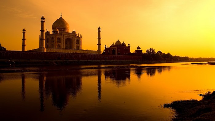 Taj Mahal reflected in river at sunset