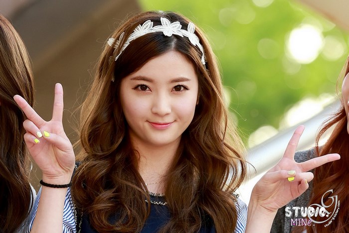 Korean girl group members posing with peace signs