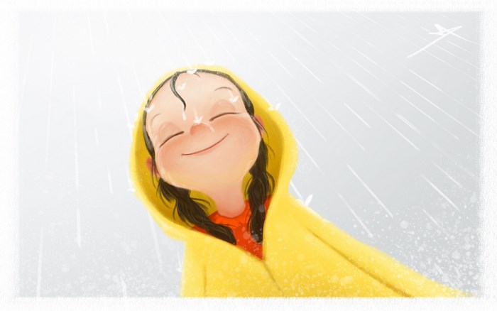 Girl in yellow raincoat enjoying the rain