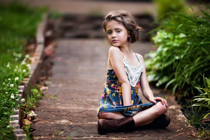 Young girl sitting on a path