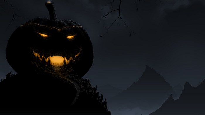 Scary Jack-o'-lantern on a dark mountain landscape