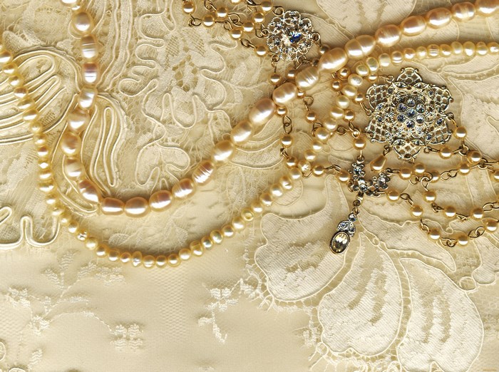 Pearl necklaces and brooches on lace