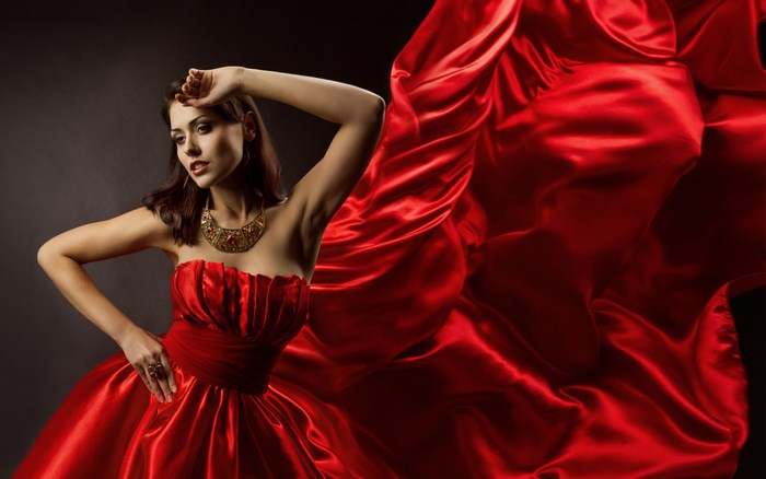 Elegant Woman in Flowing Red Satin Dress