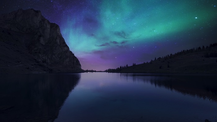 Mountain lake under aurora borealis 4K