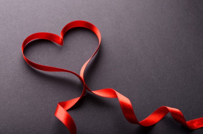 Red ribbon heart on dark background 4K