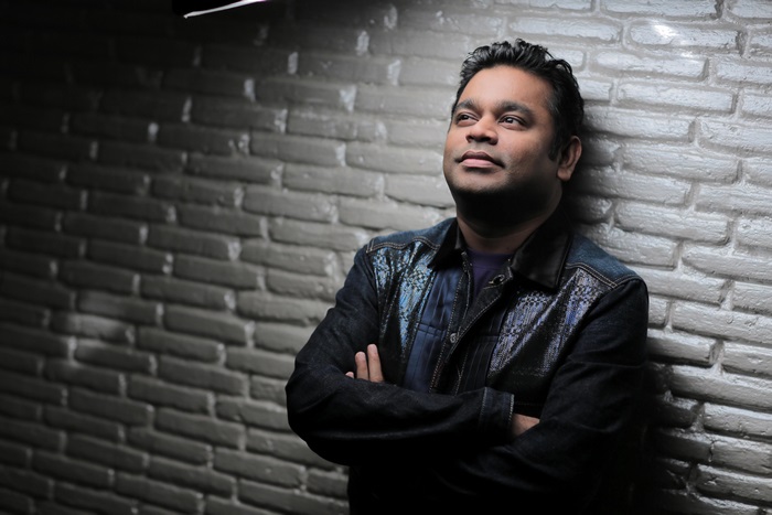 AR Rahman leaning against a brick wall