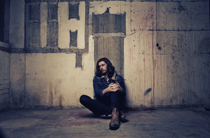 Hozier sitting in a concrete room