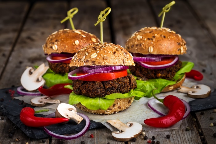 Three vegan burgers with mushrooms and chili peppers
