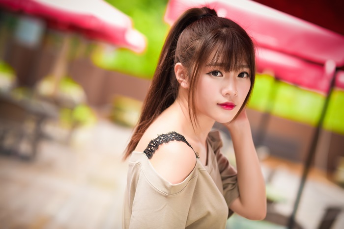 Asian woman with ponytail and off-shoulder top