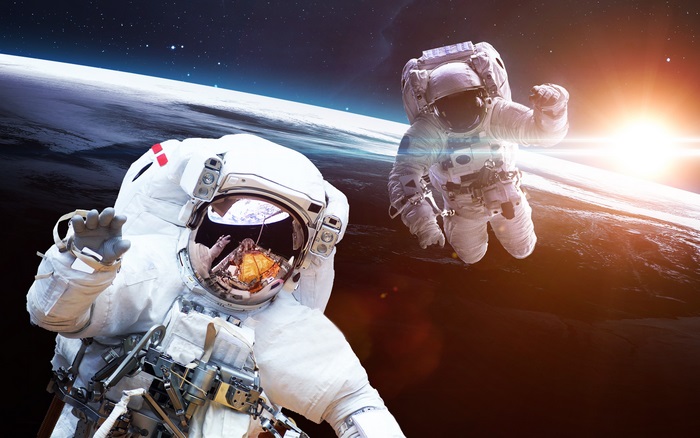 Astronauts floating in space with Earth below