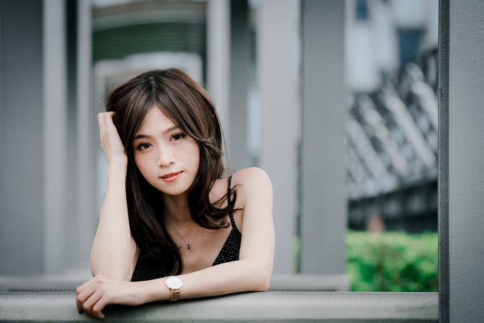 Asian woman with hand on head