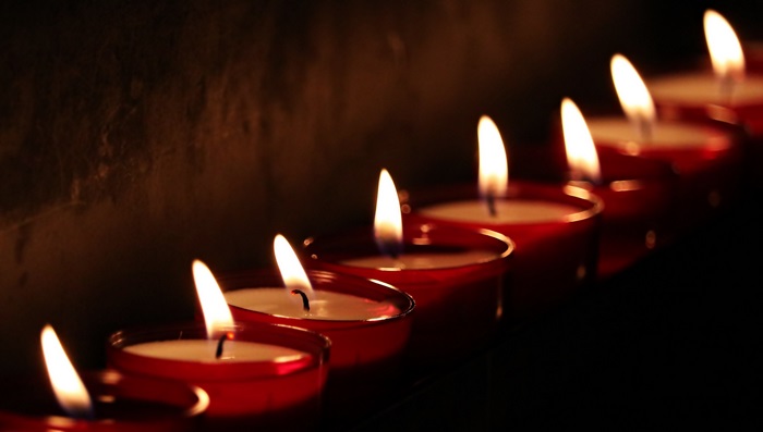 Row of lit candles in red holders
