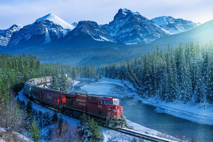 Canadian Pacific train in snowy Rocky Mountains landscape