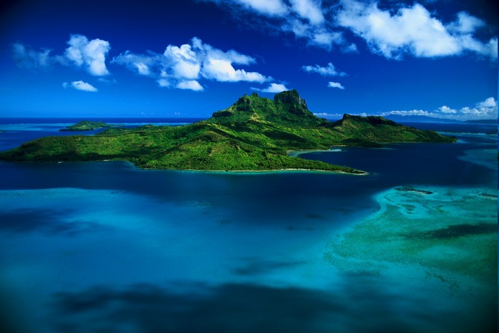Aerial view of a tropical island with mountains and blue ocean