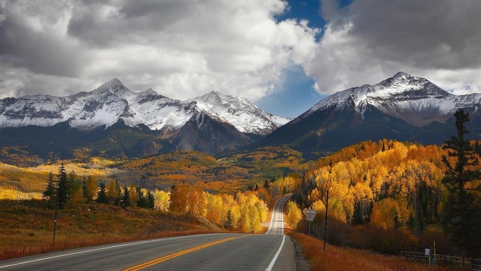 Mountain road in autumn with snow-capped peaks