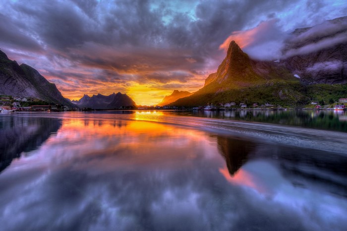 Sunrise over a Norwegian fjord with mountains and a village