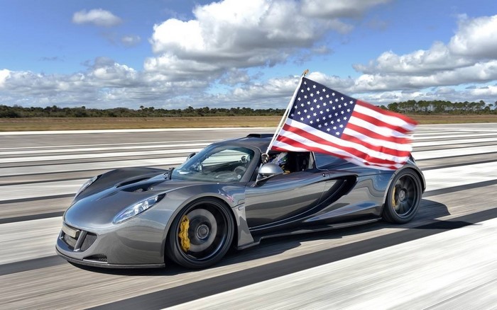 Gray sports car with American flag on a runway