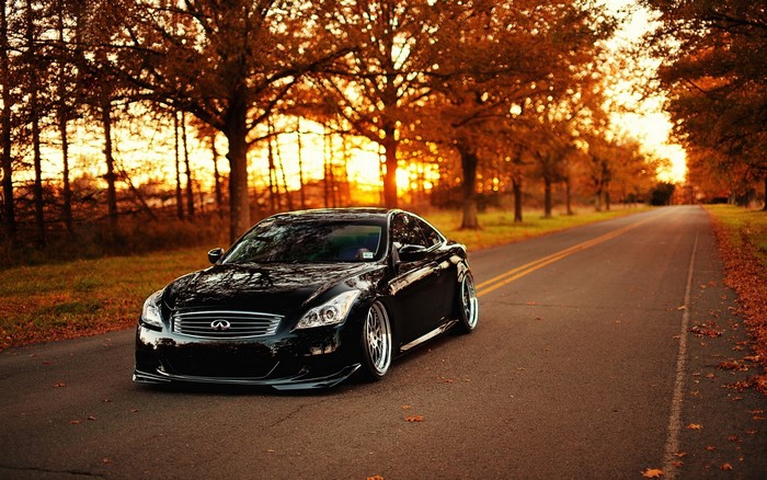 Black Infiniti G37 on a road during autumn sunset