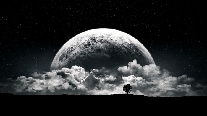 Surreal planet rising above clouds with lone tree