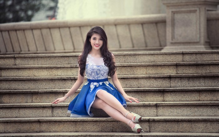 Asian Woman in Blue Dress Sitting on Stone Steps