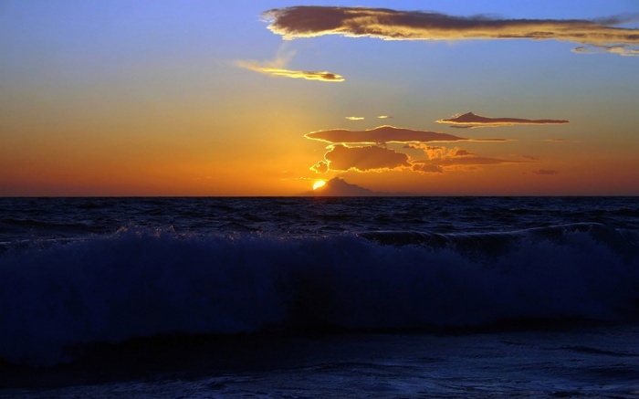 Sunset over the ocean with a distant island