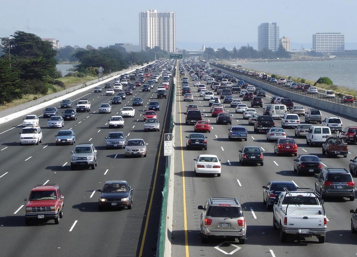 Traffic jam on a multi-lane freeway with city buildings in the background
