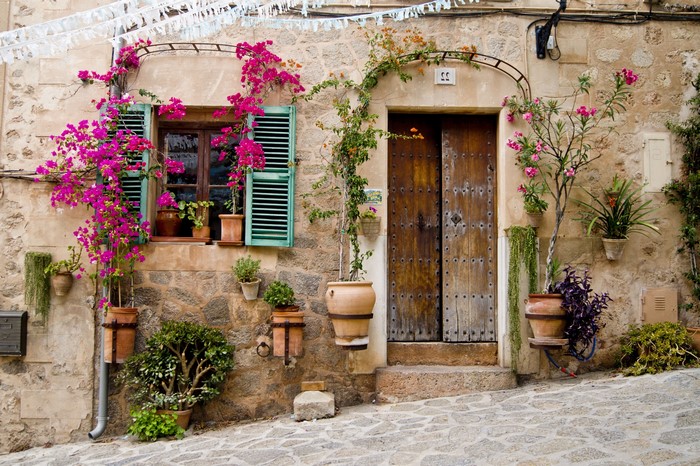 Stone house with wooden door and bougainvillea flowers