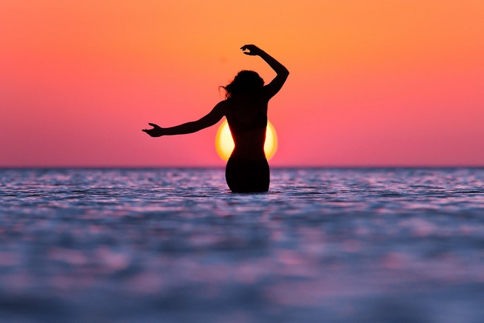 Woman in water at sunset