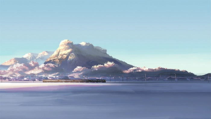 Train passing through a snowy landscape with mountains