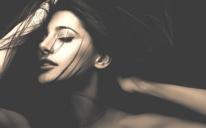 Sepia toned portrait of a woman with hands on head