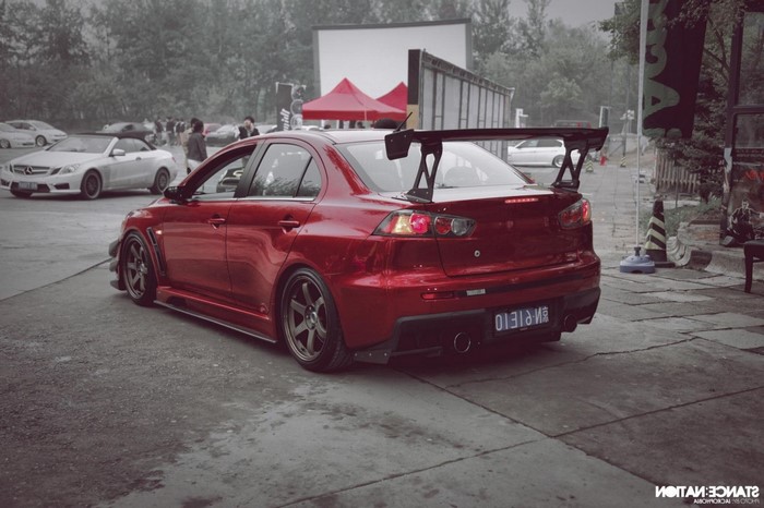 Red Mitsubishi Lancer Evo X with large rear spoiler