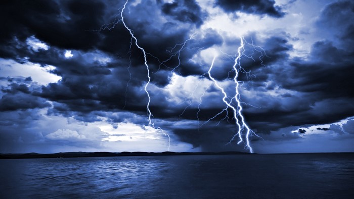 Lightning strikes over the sea during a storm
